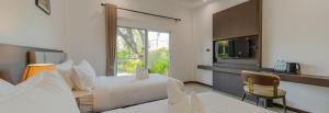 a bedroom with a bed and a tv and a chair at เวลการ์เด้น101 in Ban Hua Phrong
