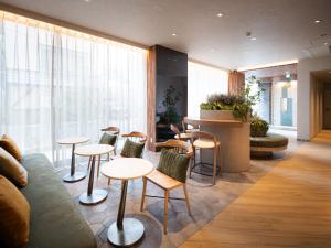 a lobby with tables and chairs and a couch at R Hotel Namba East in Osaka