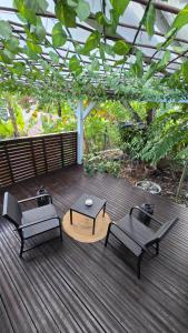 a wooden deck with two benches and a table at La Cachette in Le Marin