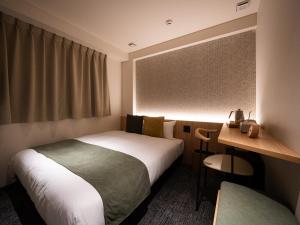 a hotel room with two beds and a desk at R Hotel Namba East in Osaka +32 photos