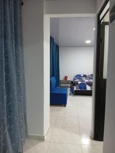 a bedroom with a blue couch and a bed at Nápoles city in Medellín