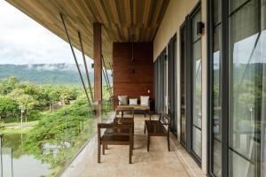 a balcony with tables and chairs on a building at atta Lakeside Resort Suite - SHA Plus Certified in Mu Si