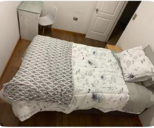 a bed with a blanket on it in a room at Habitación donde Max in Valparaíso