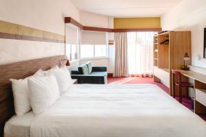 a hotel room with a bed and a chair at Statesman Hotel in Canberra +32 photos