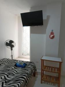 a bedroom with a bed and a table and a television at Hospedaje Anny in Larán