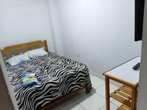 a bedroom with a zebra print bed and a table at Hospedaje Anny in Larán