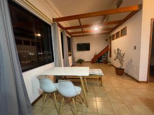 a table and chairs in a room with a large window at Habitación donde Max in Valparaíso
