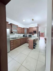 a kitchen with wooden cabinets and a white tile floor at Salvatierra Home in La Paz