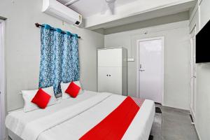 a bedroom with a large bed with red pillows at Hotel O Moonlight Inn in Nagpur