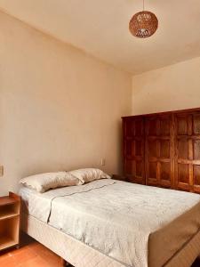 a bedroom with a bed and a wooden headboard at Apapacho Urbano Casa cómoda Ideal familias y grupos in Paysandú