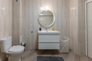 a bathroom with a white toilet and a mirror at Central 2BR - Workspace with Elevator in Varna City +41 photos
