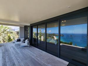 an empty house with a view of the ocean at Dreamtime Hahei in Hahei +13 photos