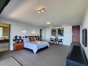 a bedroom with a large bed and a bathroom at Dreamtime Hahei in Hahei