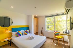 a bedroom with a large white bed and a window at goSTOPS Bengaluru, Indiranagar - Private Rooms & Dorms in Bangalore +95 photos