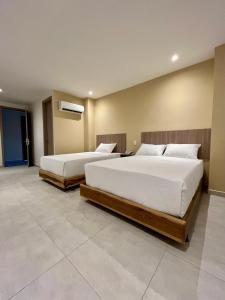 two beds in a room with two beds sidx sidx sidx sidx at BQ84 Urban Hotel in Barranquilla
