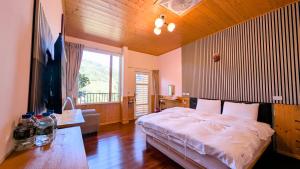 a bedroom with a bed and a large window at Chingjing ‧ orange Scotia in Ren'ai