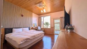 a bedroom with a large bed and a wooden ceiling at Chingjing ‧ orange Scotia in Ren'ai