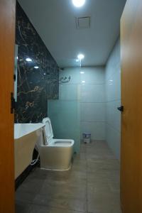 a bathroom with a white toilet and a sink at Avenue A boutique hotel in Vijayawāda