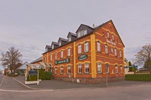 ein großes orangefarbenes Backsteingebäude auf einer Straße in der Unterkunft Der Bayerische Hof in Grünbach