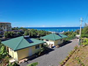 an aerial view of two houses with the ocean in the background at Honey Lodge in Punaauia