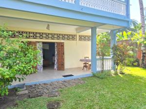 a patio of a house with a table in a yard at Chambre Bleu - Coco Room Nosy-Be in Nosy Be