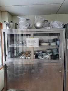 a display cabinet with dishes in it with a sign in it at 宿小町や in Senboku