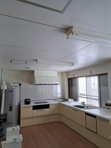 a large kitchen with white counters and appliances at 宿小町や in Senboku +15 photos