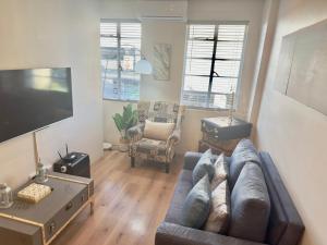 a living room with a couch and a tv at Kaneel Suiker - Paarl - Self Catering Apartment in Paarl