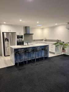 a kitchen with a large island with bar stools at Hart Road Haven in Richmond