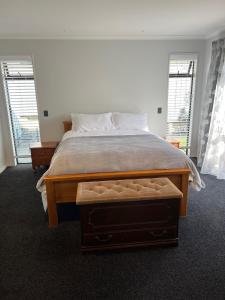 a bedroom with a large bed and two windows at Hart Road Haven in Richmond