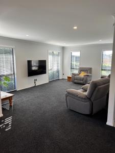 a living room with a couch and a flat screen tv at Hart Road Haven in Richmond