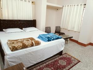 a bedroom with a bed and a chair and a table at Lotus palm in Deoghar +6 photos