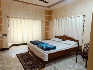 a bedroom with a bed and a window with curtains at Lotus palm in Deoghar