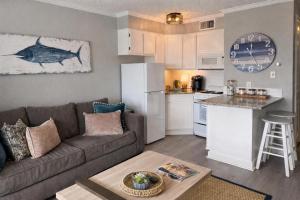 a living room with a couch and a kitchen at Luxury Beach front Condo in Galveston