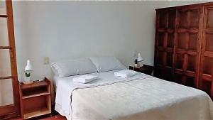 a bedroom with a white bed with two towels on it at Apapacho Urbano Casa cómoda Ideal familias y grupos in Paysandú
