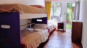 a bedroom with two bunk beds and a window at Apapacho Urbano Casa cómoda Ideal familias y grupos in Paysandú +16 photos
