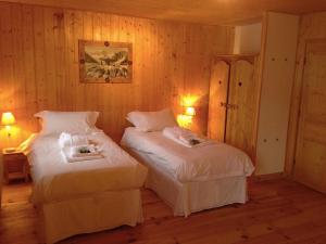 two beds in a room with wood paneling at Chalet Marie Blanche in Saint-Gervais-les-Bains