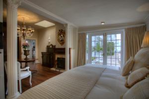 a bedroom with a large white bed and a fireplace at Our Hermanus House in Hermanus +106 photos