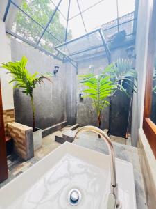 a bathroom with a sink and some plants at Sigiriya Coconut Shade Resort in Sigiriya +60 photos
