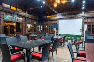 a restaurant with tables and chairs and a projection screen at De Bua Valley Resort in Wang Nam Khieo