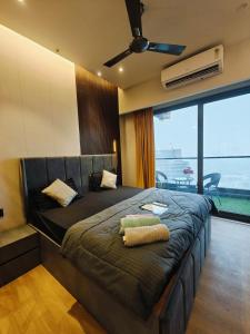 a bedroom with a large bed with a ceiling fan at KakoonStudios Balcony Bliss in Ghaziabad