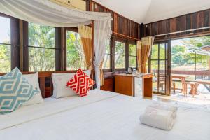 a bedroom with a large bed and windows at De Bua Valley Resort in Wang Nam Khieo +159 photos