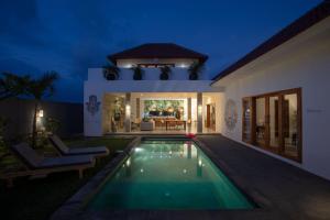 a villa with a swimming pool at night at KARMA room in Villa ABSOLUTE Shared Villa in Canggu