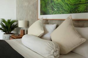 a white bed with pillows on top of it at KARMA room in Villa ABSOLUTE Shared Villa in Canggu