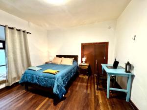 a bedroom with a bed and a desk with a laptop at Avaroa 350 in Sucre
