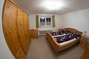 a bedroom with a bed and wooden cabinets and a window at Grimmingapartment Maier in Stainach