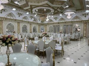 a banquet hall with white tables and chairs and flowers at Said Islom Khoja in Khiva +40 photos
