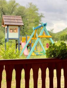 a playground with a slide and a play house at Apartmani D&S in Mokra Gora
