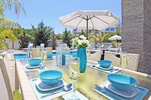 uma mesa de jantar com tigelas azuis e pratos em Villa Solebianco Protaras em Protaras