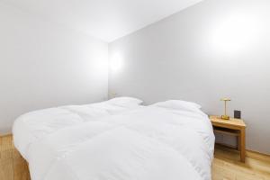 a white bed with white sheets in a bedroom at Yunagi 夕凪プライベートサウナ付ヴィラオーシャンフロントの絶景宿 夕日とサウナを満喫海と夕日に包まれる贅沢空間 in Mōrai